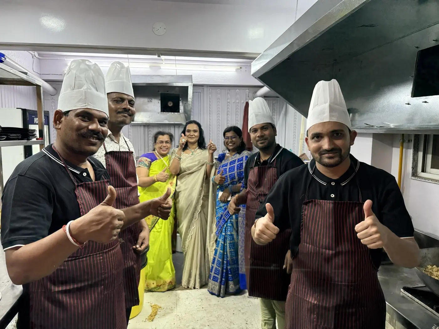The Dalchini kitchen team and family smiling together in the cafe kitchen