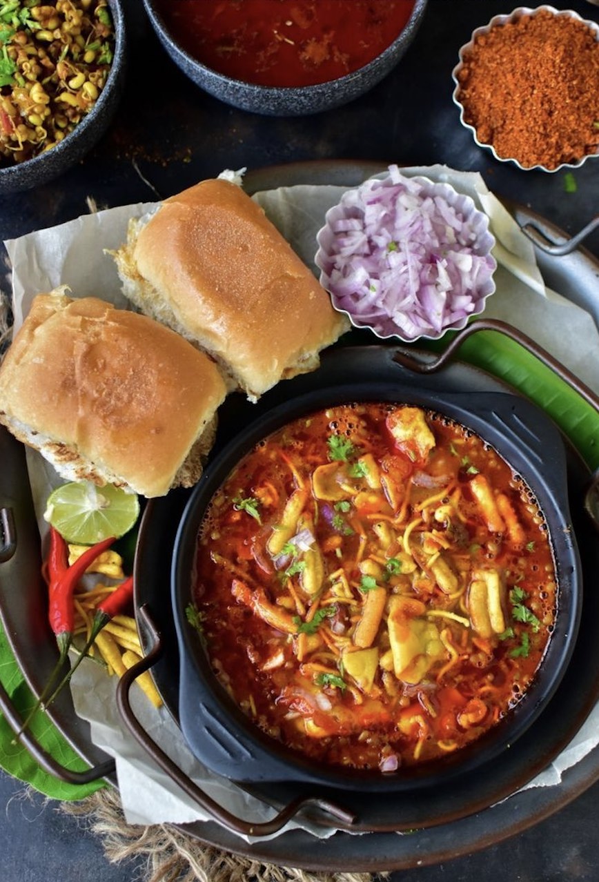 A hot plate of authentic Maharashtrian misal pav with farsan, onion and pav at Dalchini, Nashik